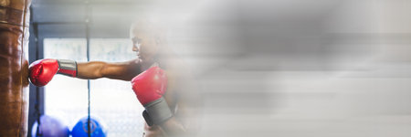 Blur effect with copy space against african american male boxer practicing boxing at the gym. sports and fitness conceptの写真素材