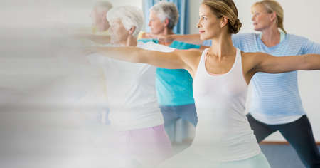 Blur effect with copy space against female yoga trainer and group of senior people performing yoga....