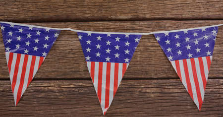 American flag design over decorative bunting flags on wooden surface. american independence and patriotism conceptの写真素材