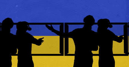 Silhouette of group of people against iron fence and ukraine flag background. ukraine crisis and...