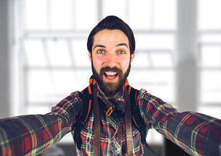 Portrait of caucasian man with backpack smiling against against office window in background. business and technology conceptの写真素材