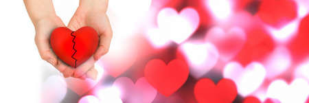 Cupped hands holding a broken heart and multiple heart icons with copy space. valentine's day...