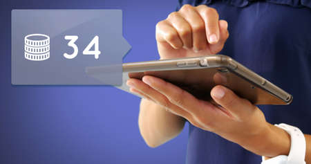 Close up of a woman typing on her tablet with a message bubble and coin count icon pointing at the...