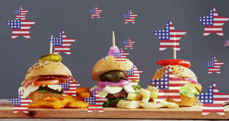 Image of stars with flag of usa over burgers lying on wooden board. american cuisine and fast food concept digitally generated image.の写真素材