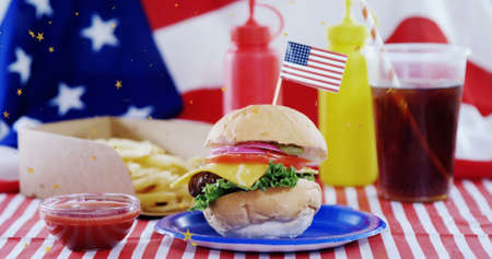Image of dust floating over burger and drinks over flag of usa. american cuisine and fast food concept digitally generated image.の写真素材