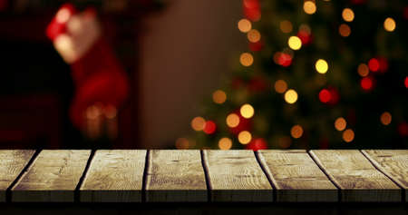 Digital composite of Wooden foreground with Christmas background of tree and stockingの写真素材