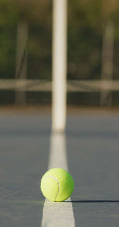 Vertical image of empty tennis court with net and tennis ball. female tennis, sport and competition.の写真素材