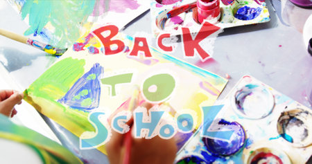 Image of back to school text over diverse schoolchildren doing art. Global education and digital interface concept digitally generated image.の写真素材