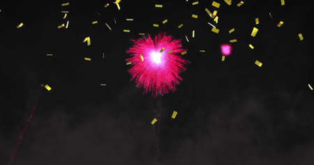 Image of pink christmas and new year fireworks and gold confetti in night sky. christmas, new year, celebration, party and tradition concept digitally generated image.の写真素材