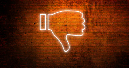 Image of glowing neon thumbs down icon on brick wall. social media and communication concept digitally generated image.の写真素材