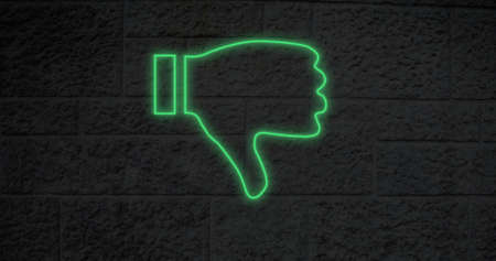 Image of glowing neon thumbs down icon on brick wall. social media and communication concept...