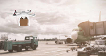 Digital image of a white drone carrying a brown box while hovering in an airport with an airplane an a truckの写真素材