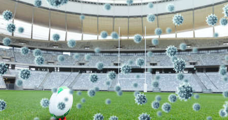 Multiple covid-19 cells floating against rugby ball on sports stadium. sports tournament and...