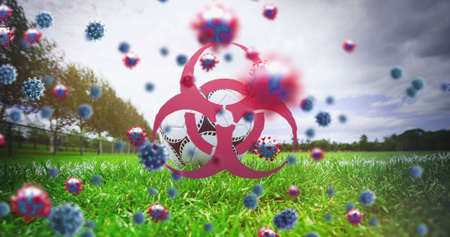 Image of 3d coronavirus cells  and biohazard symbol floating over soccer ball and empty stadium....