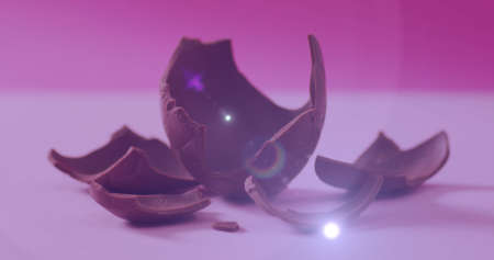 Image of light over broken chocolate egg on pink background. sweets, desserts and chocolate concept digitally generated image.の写真素材