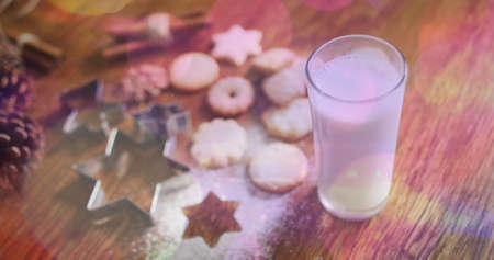 Image of light spots over milk and cookies at christmas. world milk day and christmas concept digitally generated image.の写真素材