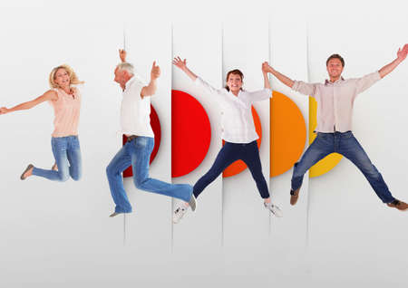 Caucasian group of people jumping in the air against colorful round shapes with copy space. people...