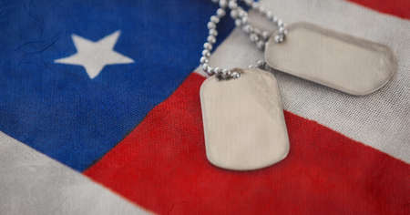 Military dog tags over american flag background with copy space. american independence and...