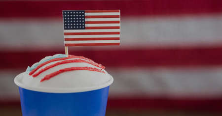 Miniature american flag over a drink against american flag background with copy space. american...