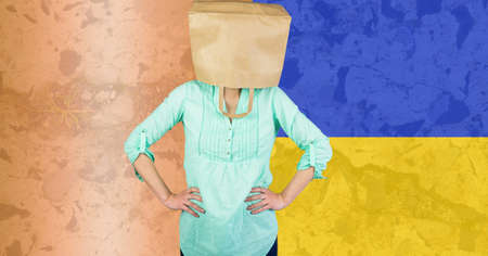 Caucasian woman with paper bag over her head against ukraine flag design background. ukraine crisis, invasion and international relations conceptの写真素材