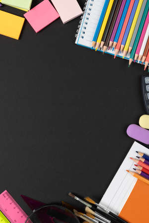 Imagine of various office supplies, pins, rulers, scissors on and notebook on black background. Education, learning and creativity.の写真素材