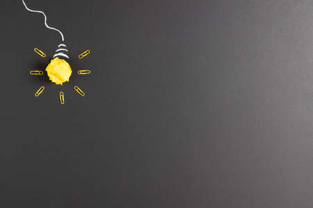 Image of a bulb made of paper ball and rockers over dark background. Education, learning and...