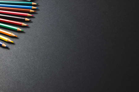 Composition of colorful crayons on black surface with copy space. School equipment, drawing tools, pattern and creativity concept.の写真素材