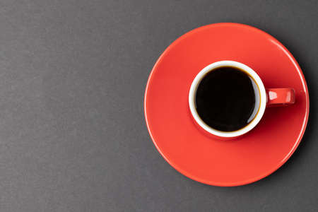 Image of red cup of hot black coffee on black background. Coffee, refreshment and beverages.