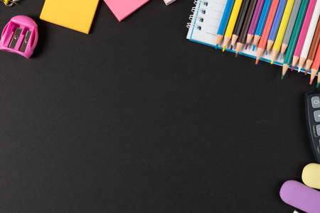 Imagine of various office supplies, pins, rulers, scissors on and calculator on black background. Education, learning and creativity.の写真素材