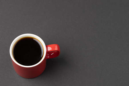 Image of red cup of hot black coffee on black background. Coffee, refreshment and beverages.の写真素材