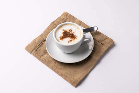 Image of white cup of coffee with milk and tea towel on white background. Coffee, refreshment and beverages.の写真素材