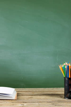 Image of school supplies, apple and notebook over drawings on black board. Education, learning and creativityの写真素材
