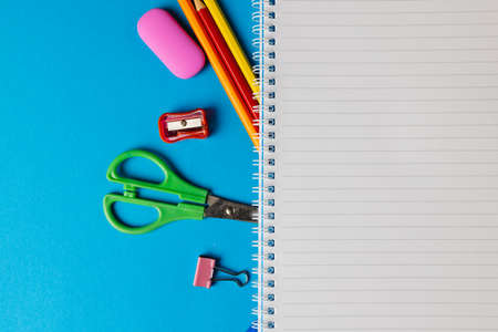 Composition of notebook with copy space and school tools on blue surface. School equipment, tools and creativity concept.の写真素材