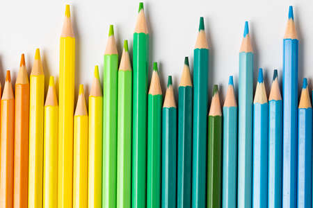 Composition of colorful crayons on white surface. School equipment, drawing tools, pattern and...