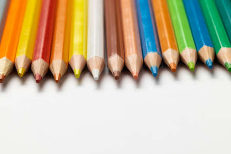 Composition of colorful crayons on white surface with copy space. School equipment, drawing tools...