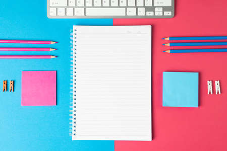 Composition of notebook with copy space, laptop and school equipment on blue and pink surface. School equipment, tools, learning and creativity concept.の写真素材