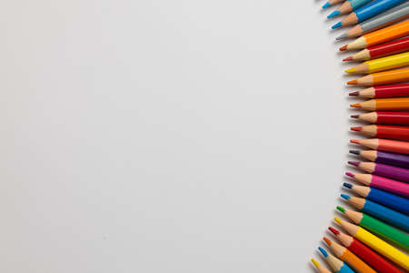 Composition of colorful crayons and other school tools on white surface with copy space. School...