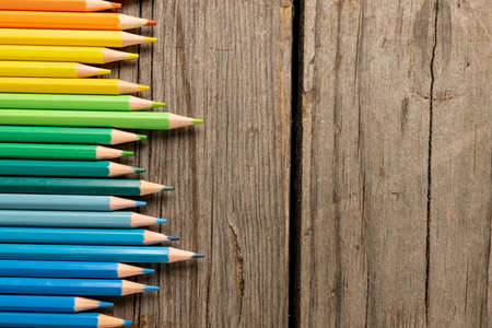 Composition of colorful crayons on wooden background. School equipment, tools, education, pattern and creativity concept.の写真素材