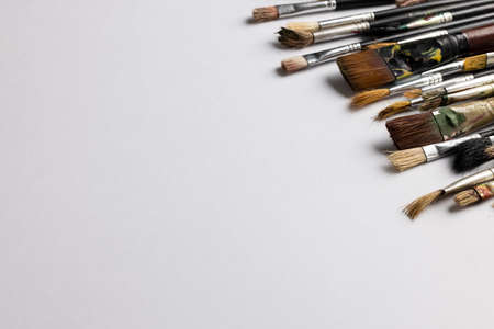 Image of composition of diverse brushes on white surface with copy space. School equipment, tools,...