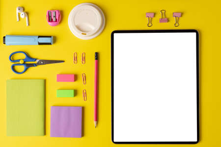 Composition of school equipment and tablet with copy space on yellow surface. School equipment, tools, learning and education concept.の写真素材