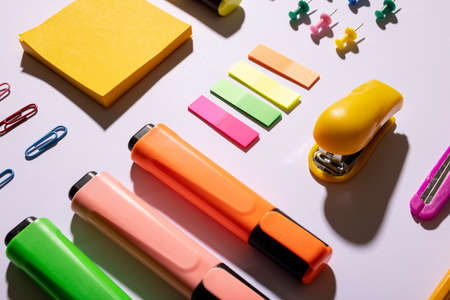 Image of composition with markers and school items on pink surface. School equipment, tools,...