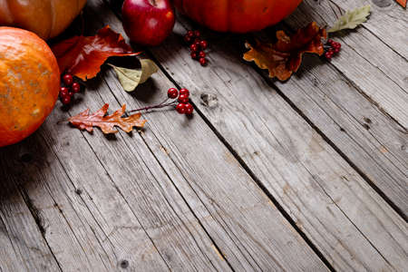 Composition of pumpkins and autumn leaves on wooden background. Halloween, autumn, tradition and celebration concept.の写真素材