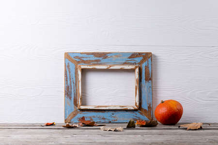 Composition of pumpkin with autumn leaves and frame with copy space on white background. Halloween, autumn, tradition and celebration concept.の写真素材