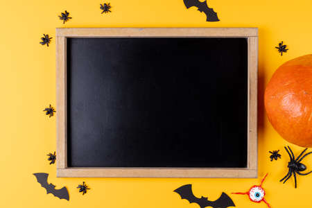 Composition of frame with copy space, halloween decorations and pumpkin on orange background. Halloween, autumn, tradition and celebration concept.の写真素材