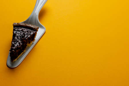 Composition of piece of pie on pie server on orange background. Halloween, autumn, tradition and celebration concept.の写真素材