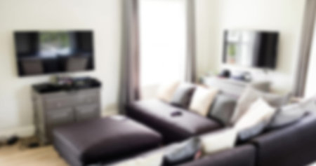Image of blurred house interior with couch and tv. Moving house concept digitally generated image.