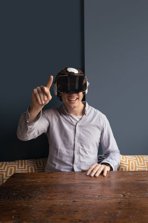 Happy man using virtual reality headset in home