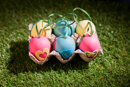 Decorated Easter eggs in crate on field