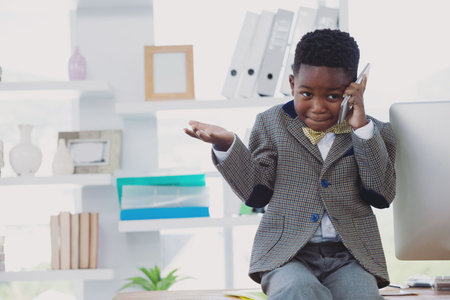 Businessman gesturing while using phone at officeの写真素材