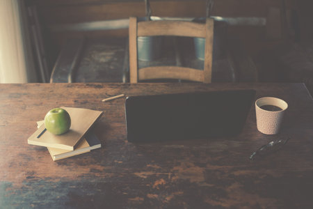 Laptop and coffee on table in officeの写真素材